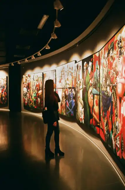 a girl looking at the artwork hanged on the wall